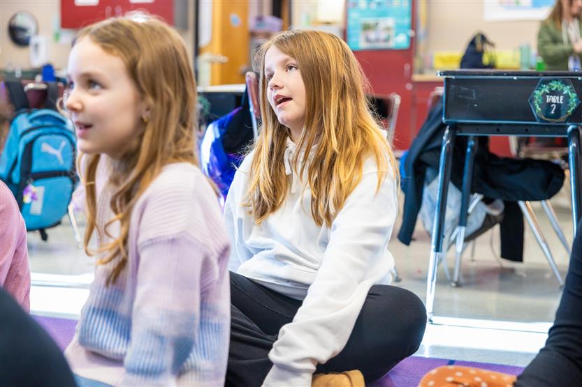 A teacher plays a ukulele for her students